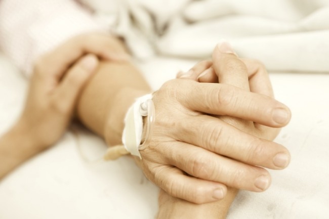 Daughter holding her mother hand in hospital